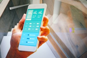 hand holding smartphone against white staircase in a modern home
